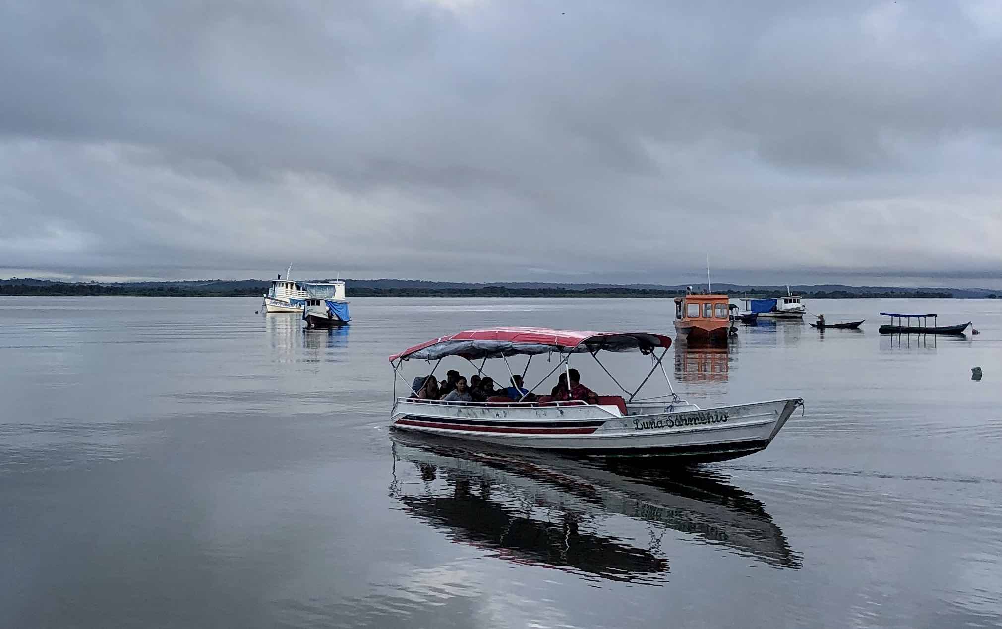 A boat with canopy with passengers on a river